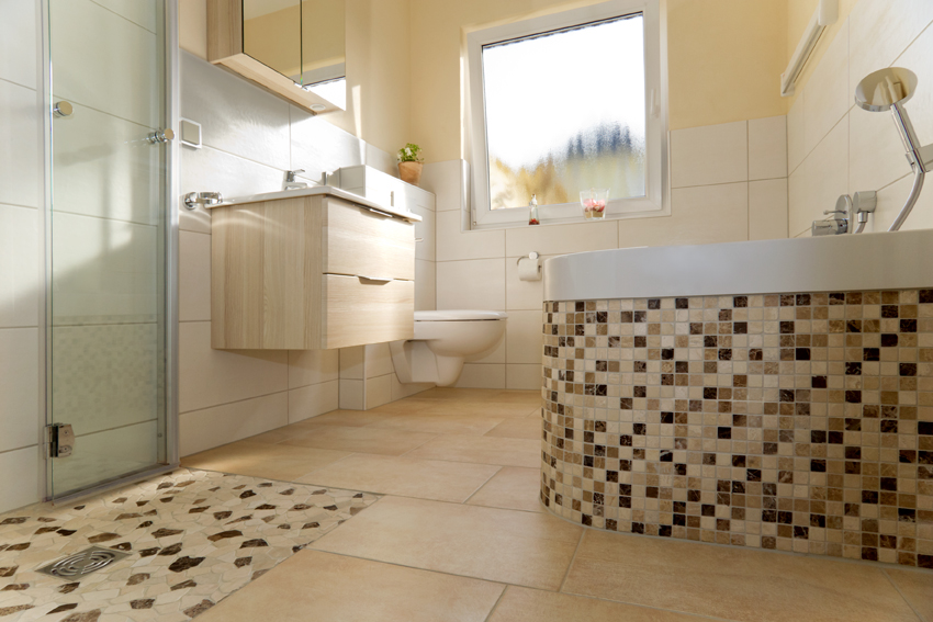 Ebenerdige Dusche mit Mosaik-Highlights auf dem Duschboden und der Badewanne